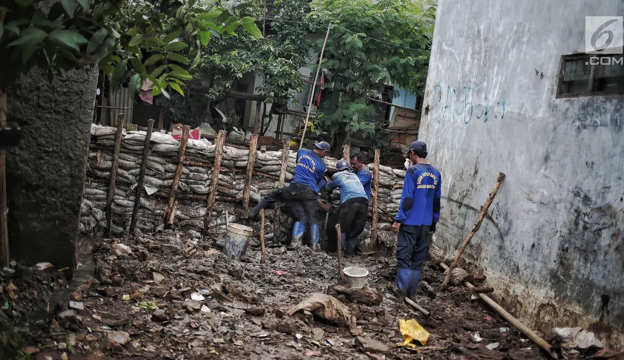 Petugas Suku Dinas SDA Jakarta Selatan membangun turap permanen di lokasi tanggul jebol di Kelurahan Jatipadang, Jakarta, Rabu (16/1). Jebolnya tanggul sempat menyebabkan permukiman warga tergenang air setinggi 30-50 cm. (Liputan6.com/Faizal Fanani)