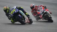 Ilustrasi balapan pada trek basah di Sirkuit Sepang, Malaysia pada MotoGP 2016. Tampak Valentino Rossi mengaspal bersama Andrea Dovizioso. (MOHD RASFAN / AFP)
