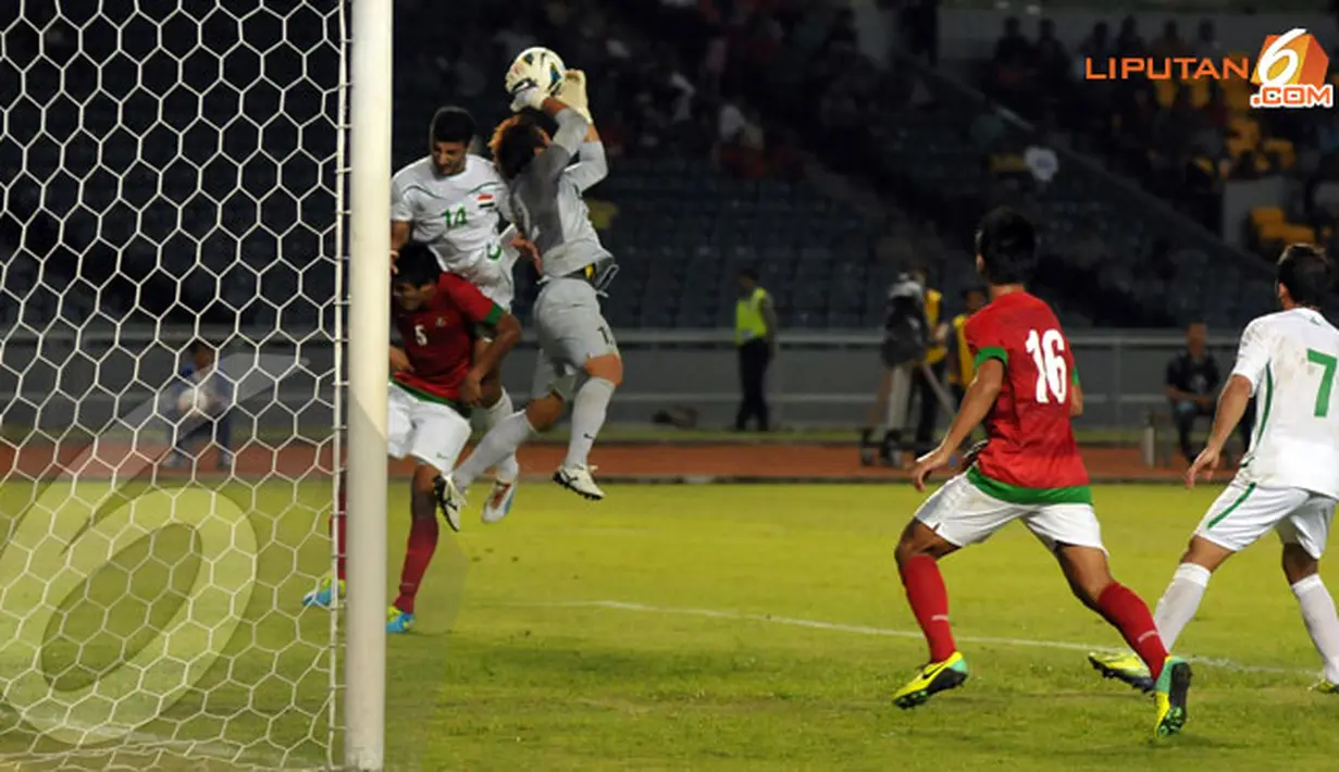 Penjaga gawang Indonesia I Made Wirawan berjibaku menahan laju serangan pemain Irak saat laga kualifikasi Piala Asia 2015 (Liputan6.com/Helmi Fithriansyah)