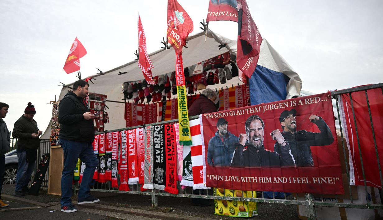 Sejumlah bendera, syal, dan spanduk bergambar Jurgen Klopp dijual di toko merchandise di area dekat Stadion Anfield, Liverpool saat laga putaran keempat Piala FA antara Liverpool melawan Norwich City pada Minggu (28/01/2024). (AFP/Paul Ellis)