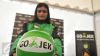 Seorang wanita memamerkan helm yang bertuliskan Go-Jek usai diterima sebagai pengendara Go-Jek di Hall A Basket Senayan, Jakarta, Jumat (14/8/15). Fenomena ojek online dengan aplikasi di hanphone kini banyak diminati. (Liputan6.com/Herman Zakharia)