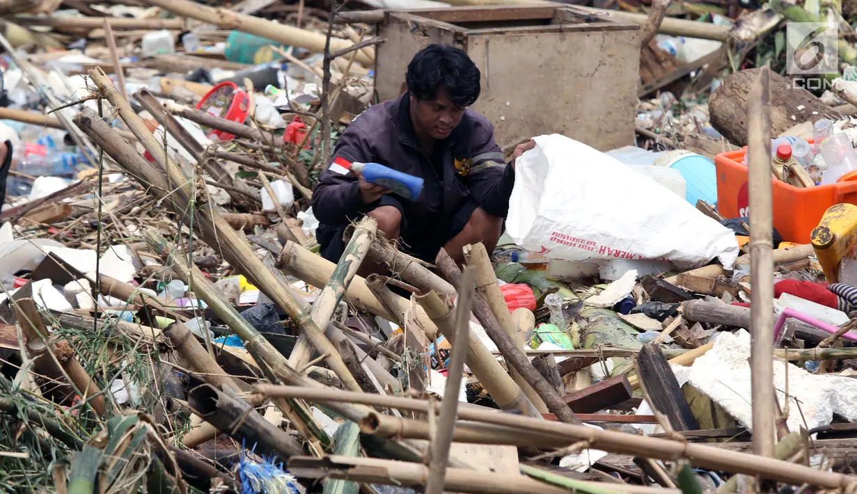Pemulung mencari sisa barang yang masih bisa dimanfaatkan diantara tumpukan sampah di Pintu Air Manggarai, Jakarta, Jumat (26/4). Sampah ini terbawa arus sungai Ciliwung akibat curah hujan yang tinggi di kawasan Bogor dan sekitarnya, Kamis (25/4). (Liputan6.com/Helmi Fithriansyah)
