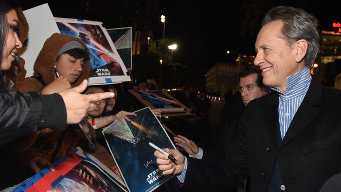 Aktor Richard E. Grant memberikan tanda kepada penggemar saat menghadiri pemutaran perdana 