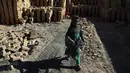 Seorang anak membawa sisa batu bara yang digunakan di pabrik batu bata di pinggiran Kabul, Afghanistan, Rabu (12/6/2019). Ribuan anak Afghanistan bekerja mencari uang untuk menghidupi keluarga mereka. (AP Photo/Rahmat Gul)