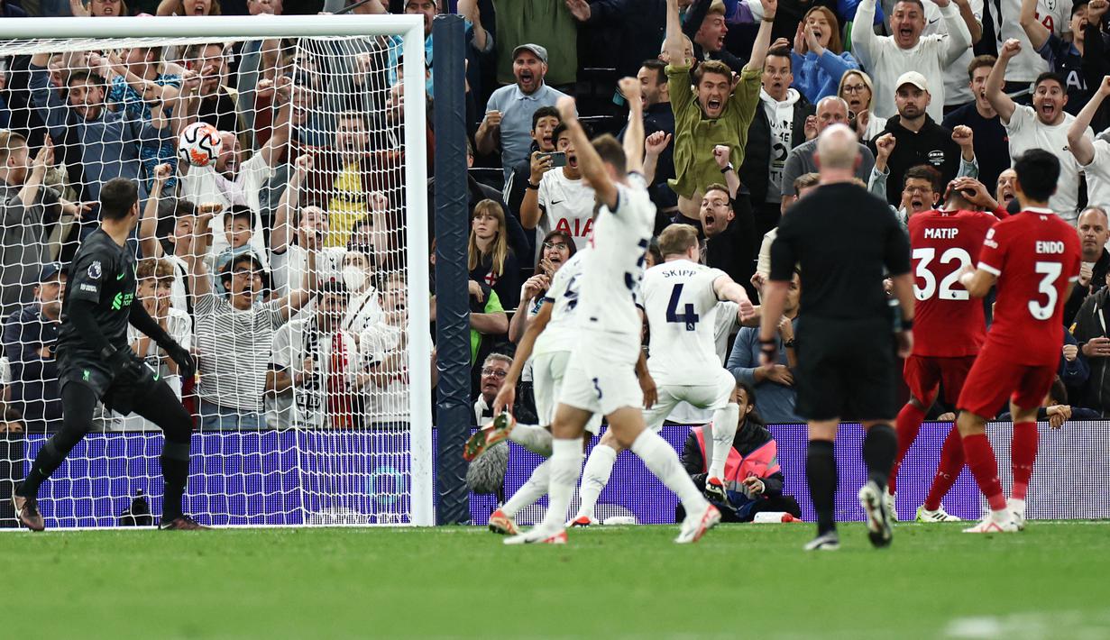 Kiper Liverpool, Alisson Becker, hanya mampu memandangi bola yang masuk ke gawangnya saat melawan Tottenham Hotspur pada laga pekan ketujuh Premier League 2023/2024 di Tottenham Hotspur Stadium, Sabtu (30/09/2023). (AFP/Henry Nicholls)