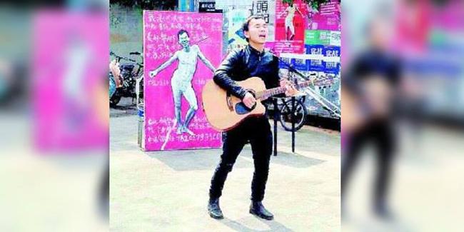 He bermain gitar dengan latar foto setengah telanjang dirinya. | Foto: copyright shanghaiist.com