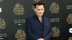 Aktor tampan Johnny Depp berpose saat menghadiri premiere film 'Alice Through The Looking Glass' di Hollywood, California, 23 Mei 2016. Pria 52 tahun itu tampil dengan setelan biru dongker. (Frederick M. Brown/GETTY IMAGES NORTH AMERICA/AFP)