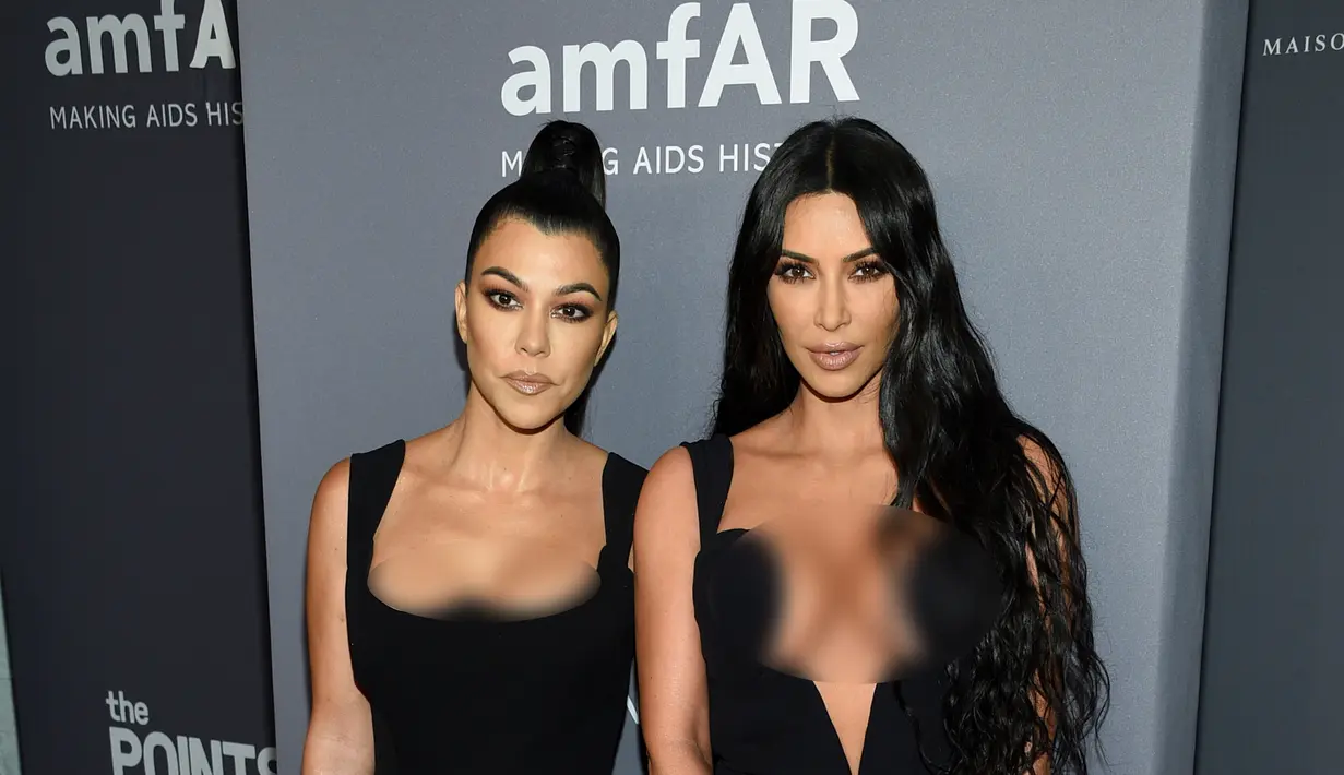 Kim Kardashian (kanan) dan Kourtney Kardashian berpose saat menghadiri Gala amfAR New York AIDS 2019 di Cipriani Wall Street, Rabu (6/2). (Photo by Evan Agostini/Invision/AP)