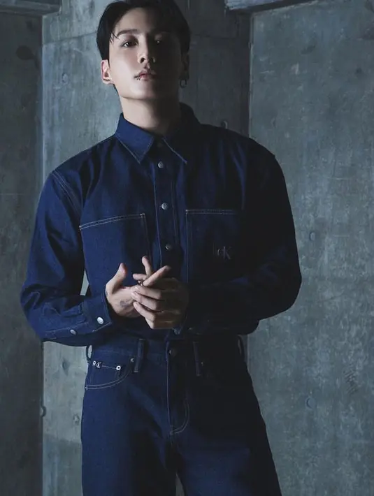 Sebagai Brand Ambassador, Jungkook BTS hadir mengenakan denim on denim. Dengan atasan jaket denim berlogo CK, dipadukan celana denim panjangnya. [Calvin Klein]
