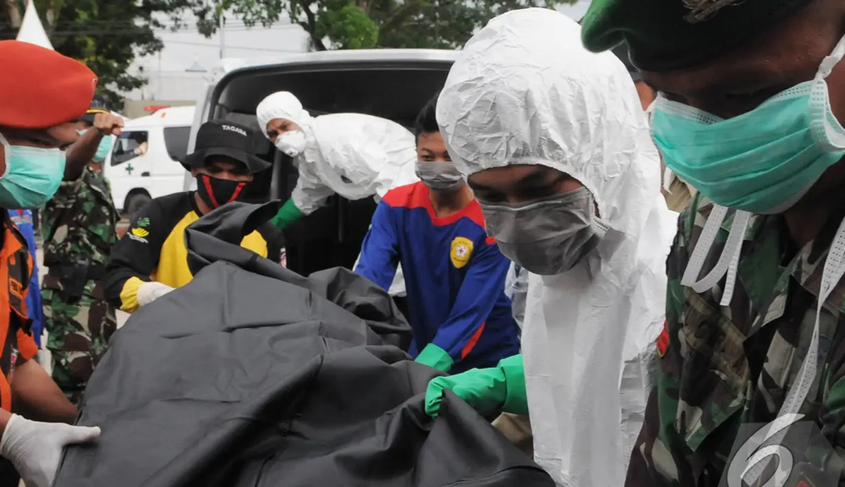 Relawan PMI mengeluarkan jenazah penumpang AirAsia QZ8501 dari dalam ambulan, Pangkalan Bun, Kalteng, Senin (5/1/2015). (Liputan6.com/Herman Zakharia)