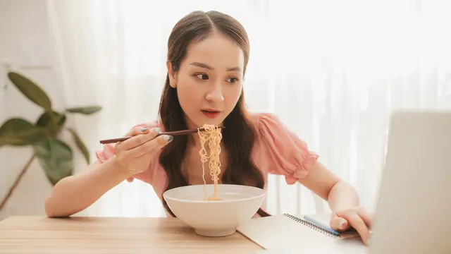 Ilustrasi perempuan menikmati mie instan.