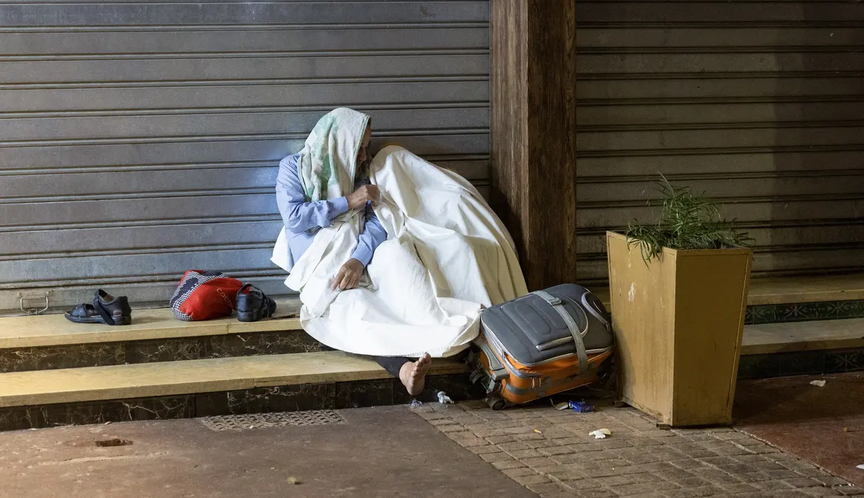 Penduduk berlindung di luar toko-toko yang tutup setelah gempa bumi di Marrakesh, Maroko pada 9 September 2023. (Photo by FADEL SENNA / AFP)