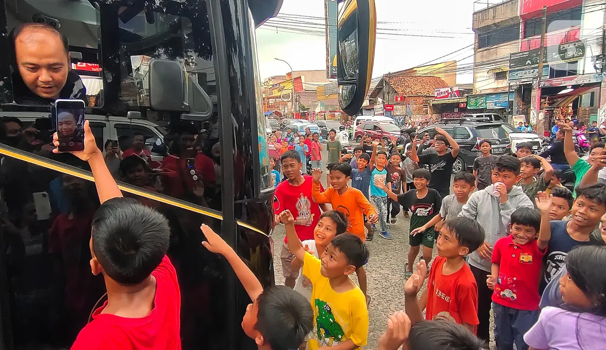 Keriuhan anak-anak saat meminta sopir bus AKAP membunyikan klakson basuri di Jalan Raya Ciledug, Tangerang, Minggu (18/6/2023). (Liputan6.com/Angga Yuniar)