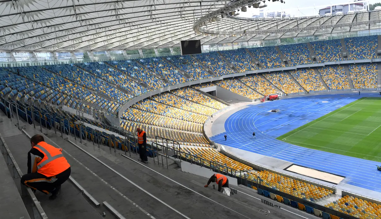 Pekerja melakukan perawatan pada stadion NSC Olimpiyskiy di Kiev, Senin (14/5). Stadion NSC Olimpiyskiy ini telah ditujuk UEFA sebagai venue final Liga Champions 2018 antara Real Madrid vs Liverpool pada 26 Mei mendatang. (AFP/Sergei SUPINSKY)