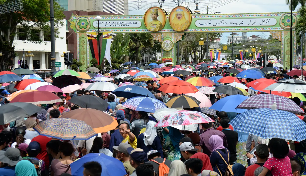 Ribuan warga rela menunggu kadatangan Sultan Hassanal Bolkiah dan Ratu Saleha Brunei pada prosesi Golden Jubilee di Bandar Seri Begawan (5/10). Perayaan tersebut menandai 50 tahun bertahta. (AFP PHOTO / Roslan Rahman)