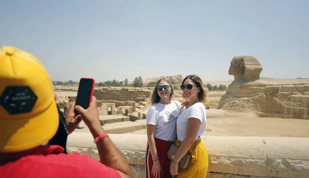 Sejumlah wisatawan berfoto di dekat Sfinks di Giza, Mesir (1/7/2020). Mesir pada Rabu (1/7) membuka kembali Museum Mesir, Piramida Giza, dan Kuil Luxor untuk kali pertama sejak ditutup akibat COVID-19 pada Maret lalu. (Xinhua/Ahmed Gomaa)
