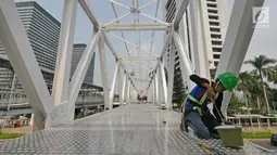 Pekerja melakukan pengecatan di Jembatan Penyebrangan Orang (JPO) Dukuh Atas, Jakarta, Rabu (3/10). Rencananya Pemprov DKI Jakarta akan merelokasi JPO Dukuh Atas namun belum dapat dipastikan kapan dilaksanakan. (Liputan6.com/Herman Zakharia)