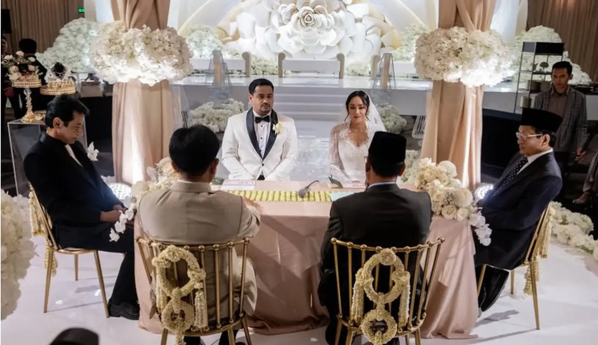 Terlihat ia memadukan wedding gownnya dengan veil panjang. Rambutnya diikat ke belakang dengan poni membingkai wajahnya. Wajahnya tampak dirias flawless. [@nasaruddin_umar]