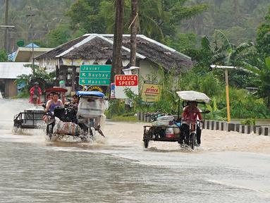 Pengendara mobil mengarungi jalan yang banjir setelah hujan lebat akibat badai tropis Agaton di Kota Abuyog, Provinsi Leyte, Filipina, 11 April 2022. (Bobbie ALOTA/AFP)