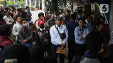 Ratusan warga menunggu panggilan untuk menyerahkan surat lamaran sebagai petugas Penanganan Prasarana dan Sarana Umum (PPSU) di halaman Loket Penerimaan Surat dan Barang, Balai Kota Jakarta, Selasa (22/4/2025). (Liputan6.com/Angga Yuniar)