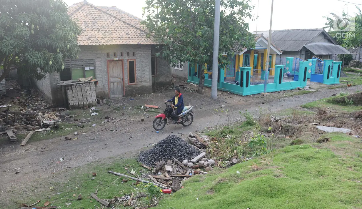 Pengendara motor melintas di dusun Regahan Lada, Pulau Sebesi, Lampung, Senin (31/12). Banyak warga dusun ini yang bertahan dan enggan meninggalkan rumahnya pascatsunami Selat Sunda pada 22 Desember lalu. (Liputan6.com/Herman Zakharia)