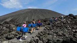 Sejumlah wisatawan berjalan mendaki untuk menikmati sandboarding atau berseluncur pasir menuruni gunung berapi Cerro Negro di Leon, Nikaragua, 24 September 2016. Gunung Cerro Negro salah satu gunung api yang masih aktif di Nikaragua. (INTI Ocon/AFP)