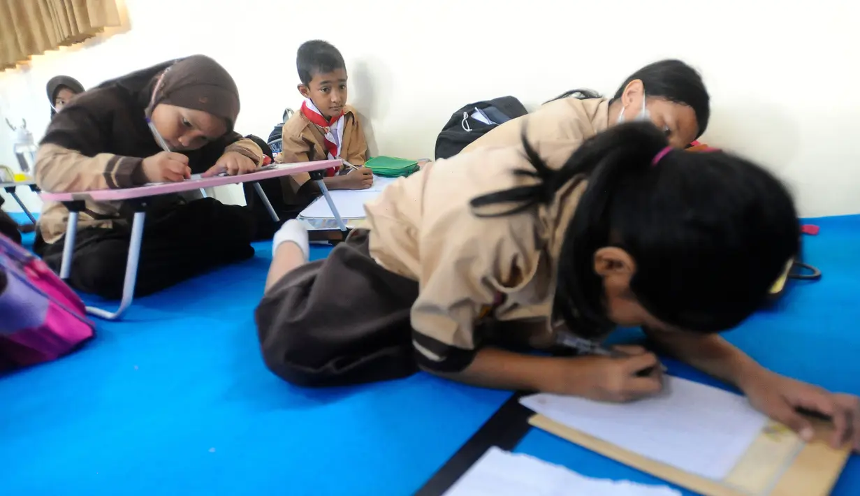 Aktivitas belajar sejumlah siswa tanpa fasilitas meja dan kursi sekolah, di SDN Bojong Nangka 02, Kabupaten Bogor, Jawa Barat, Kamis (16/2/2023). Sudah lebih dari dua pekan, murid-murid di tiga ruang kelas  menerapkan kegiatan belajar mengajar beralas karpet karena belum tersedianya bangku dan meja. (merdeka.com/Arie Basuki)