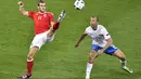 Aksi Gareth Bale (kiri) saat melewati hadangan pemain Rusia, Denis Glushakov pada laga grup B Euro cup 2016 di Stadion Municipal, Toulouse, Selasa (21/6/2016) dini hari WIB. Wales menang 3-0. (AFP/Pascal Pavani)