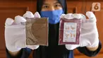 Pekerja menunjukkan pouch gemilang berisikan sabun cuci tangan berukuran kertas di Gemilang Craft Pamulang, Tangerang Selatan, Kamis (23/4/2020). Sebagian hasil penjualan produksi yang telah mencapai 2000 buah tersebut di donasikan dalam bentuk sembako dan baju hazmat. (Liputan6.com/Fery Pradolo)