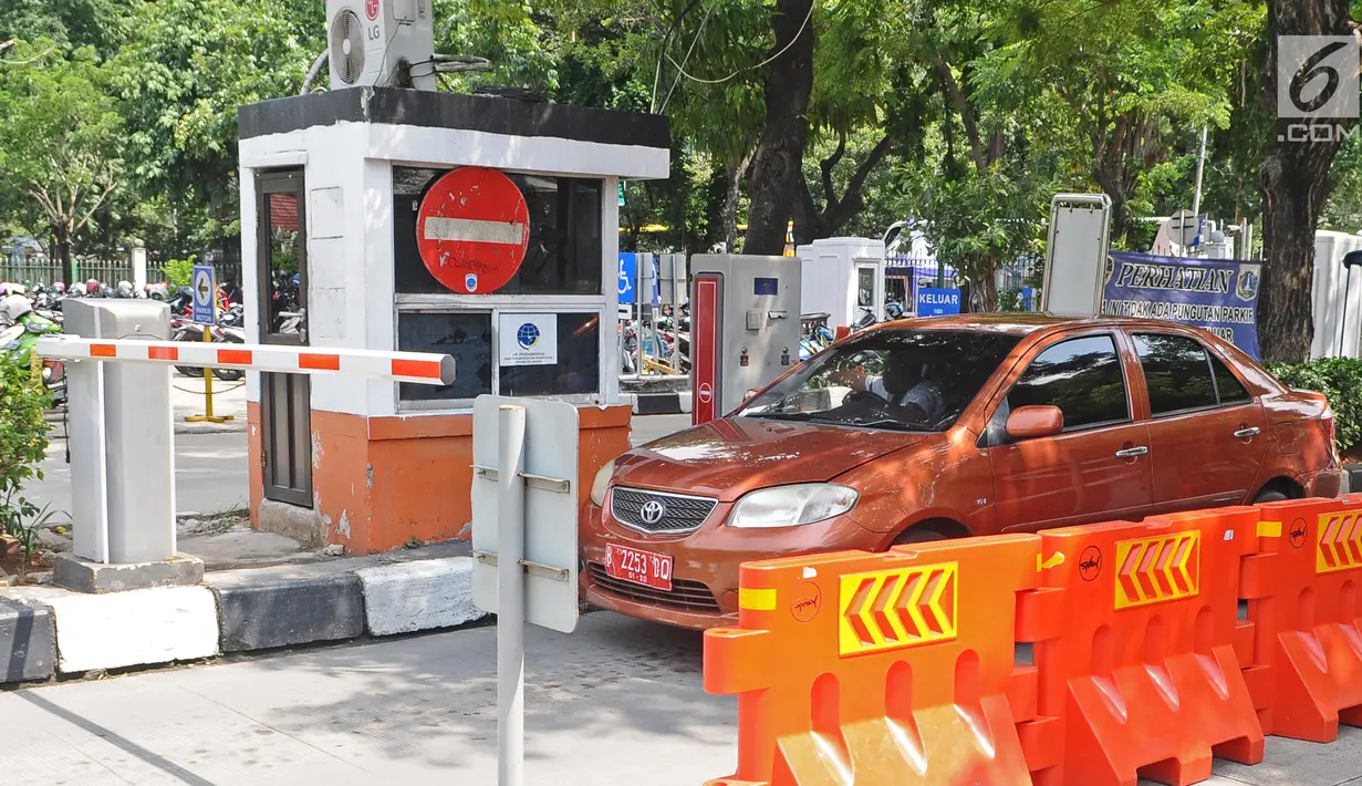 Pengendara mobil mengambil tiket parkir di parkiran IRTI kawasan Monas, Jakarta, Jumat (11/1). Pemerintah DKI Jakarta mencabut insentif parkir kendaraan ASN atau PNS di IRTI Monas, Jakarta Pusat. (Liputan6.com/Herman Zakharia)