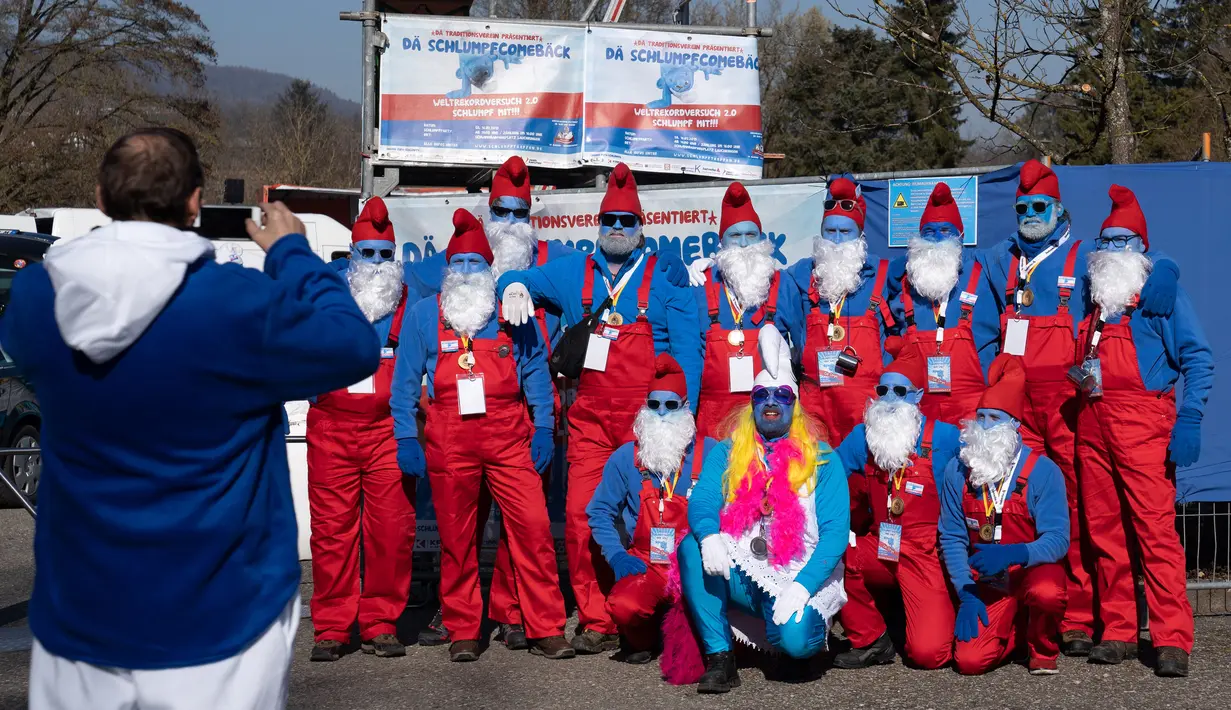 Peserta berfoto selama pertemuan orang-orang berpakaian Smurf dalam upaya pemecahan rekor dunia di Lauchringen, Jerman, 16 Februari 2019. Smurf merupakan karakter yang dibuat oleh kartunis Belgia, Pierre Culliford pada 1950. (CONSTANT FORME-BECHERAT/AFP)
