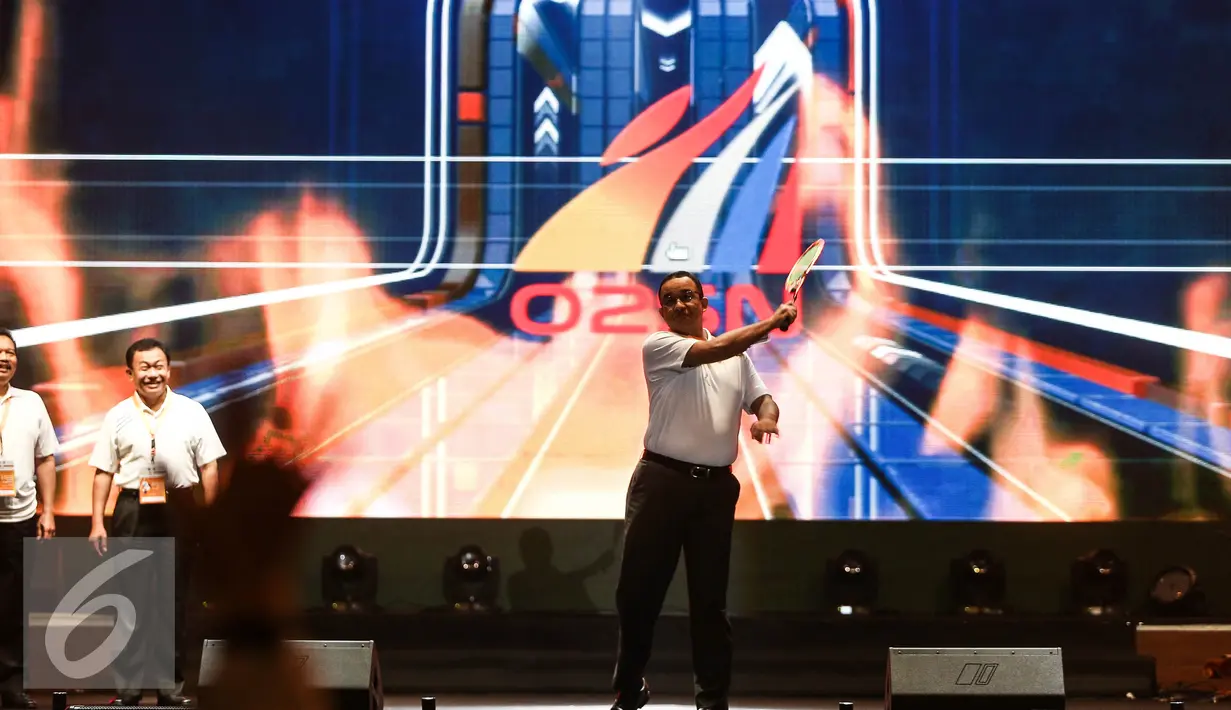 Mendikbud Anies Baswedan memukul bola badminton sebagai tanda pembukaan kontingen Olimpiade Olahraga Siswa Nasional (O2SN) di Jakarta, Senin (25/7). (Liputan6.com/Faizal Fanani)