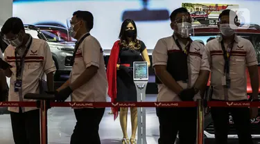 Sales Promotion Girl berdiri dekat mobil yang dipamerkan di Indonesia International Motor Show (IIMS) Hybrid 2021, JiExpo Kemayoran, Jakarta, Kamis (16/4/2021). Pameran otomotif IIMS Hybrid 2021 berlangsung pada 15-25 April. (Liputan6.com/Johan Tallo)