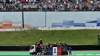 Para pebalap F1 mengikuti parade dengan truk yang dipasangi bendera Prancis sebagai tanda duka terhadap para korban serangan teroris sebelum dimulainya start F1 GP Brasil di Sirkuit Interlagos, Sao Paulo, Brasil, (15/11/2015). (AFP Photo/Nelson Almeida)