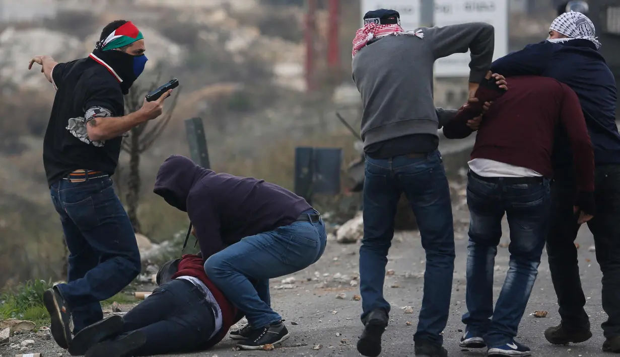 Polisi Israel menangkap dua demonstran Palestina dalam bentrokan menyusul demonstrasi menentang keputusan Presiden AS, Donald Trump terkait Yerusalem sebagai ibu kota Israel, di kota Ramallah, Tepi Barat, (13/12). (AP Photo / Nasser Shiyoukhi)