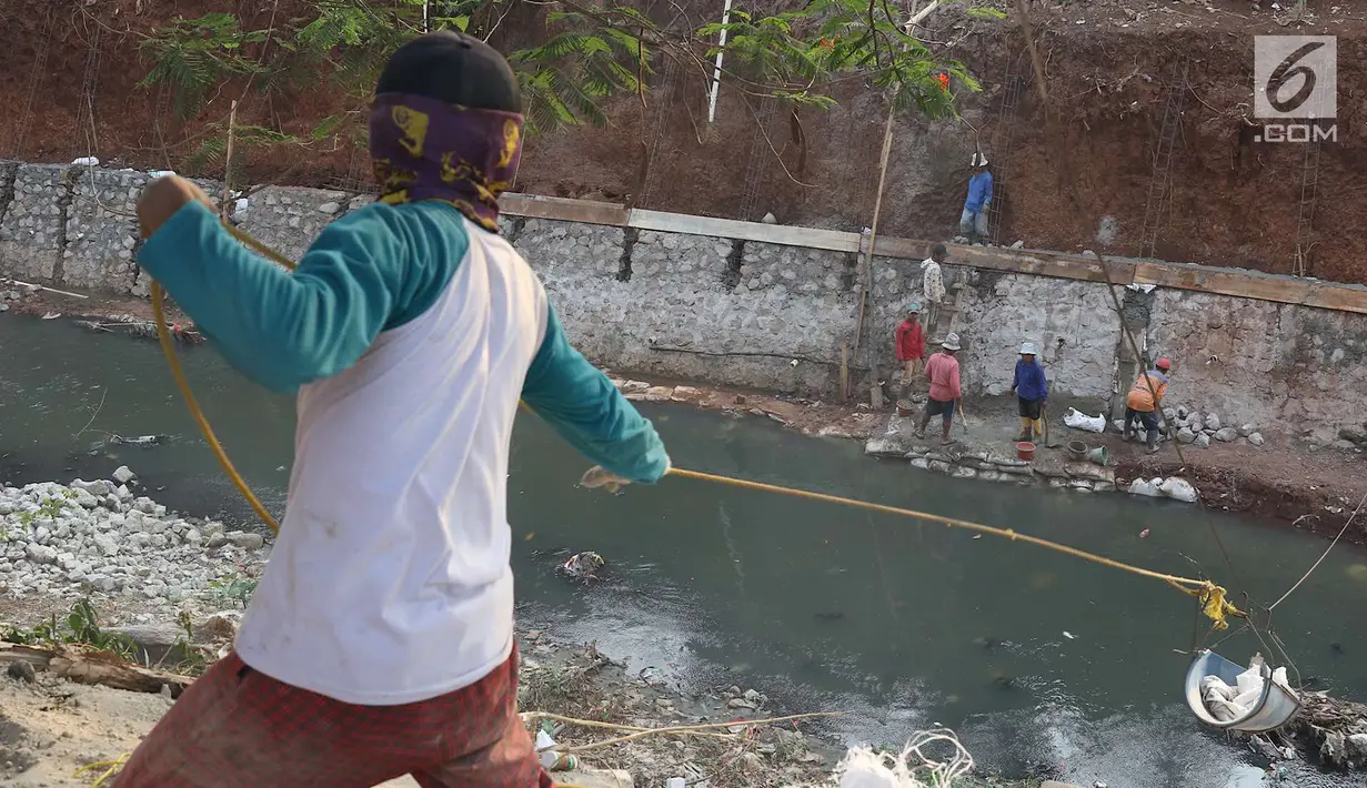 Pekerja membangun turap di bantaran Kali Cijantung, Jakarta Timur, Kamis (11/10). Pembangunan turap bertujuan mencegah longsor yang dapat membahayakan warga sekitar. (Liputan6.com/Immanuel Antonius)