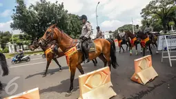 Anggota polisi berkuda berjaga di depan Istana Merdeka, Jakarta, Kamis (12/1). Aksi tersebut tidak hanya digelar di Jakarta, tetapi serentak di 18 kota lainnya di seluruh Indonesia. (Liputan6.com/Faizal Fanani)
