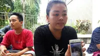 Salah satu anggota keluarga memperlihatkan foto pasangan suami istri, Joko Setiono dan Tutik Sri Pujiati yang tewas ditabrak mobil di dekat Tugu Jogja, Yogyakarta. (Liputan6.com/Fathi Mahmud)