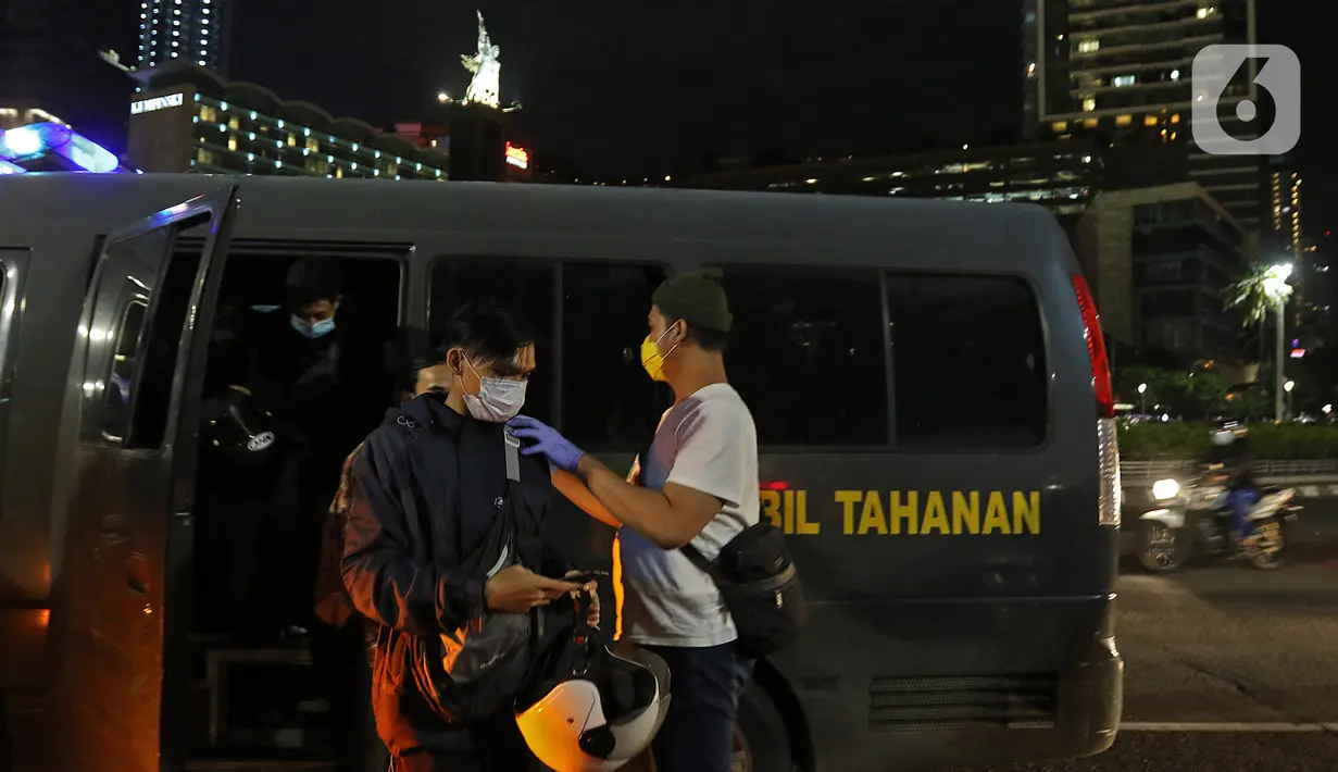 Sejumlah pemuda terjaring patroli penegakan protokol kesehatan COVID-19 di bawa ke pos polisi bundaran HI, Jakarta Pusat, Sabtu (26/12/2020). Dalam kegiatan tersebut, aparat mengamankan sejumlah pemuda untuk dilakukan Rapid Test secara massal dan diberi sanski menyapu. (Liputan6.com/Herman Zakharia)