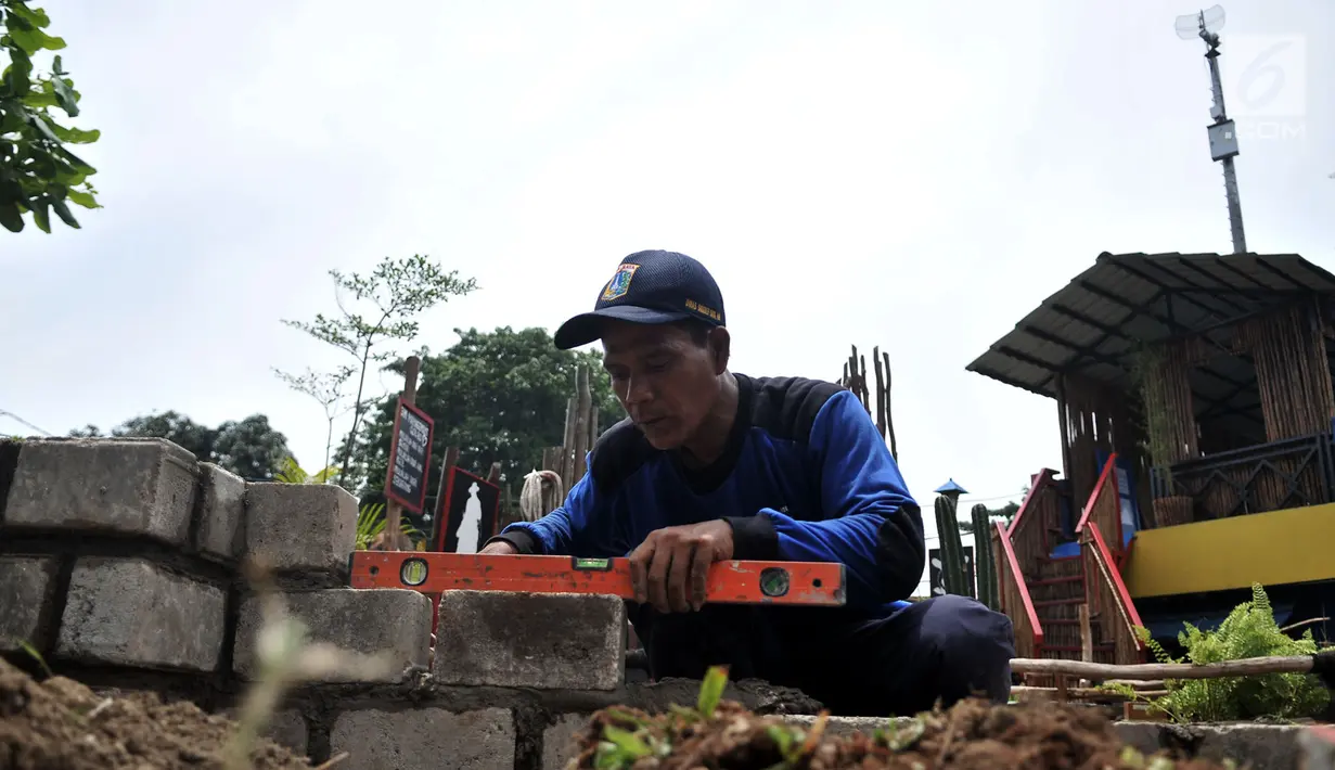 Petugas dari Dinas Sumber Daya Air (SDA) Bidang Aliran Tengah saat menyelesaikan pembangunan Taman Robika di Pintu Air Manggarai, Jakarta, Kamis (14/3). (merdeka.com/Iqbal S. Nugroho)