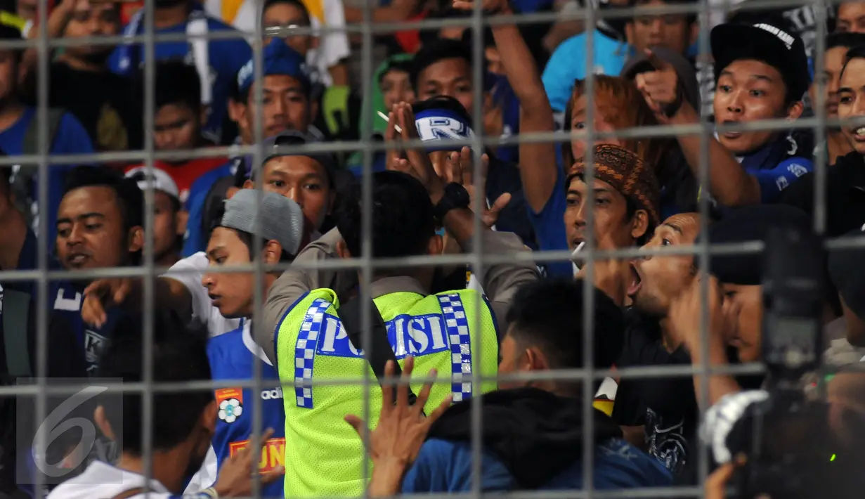 Personel polisi berusaha menenangkan suporter saat laga final Piala Bhayangkara 2016 antara Arema Cronus vs Persib di Stadion GBK Jakarta, Minggu (3/4/2016). Laga diwarnai aksi protes dari suporter dan official Persib. (Liputan6.com/Helmi Fithriansyah)