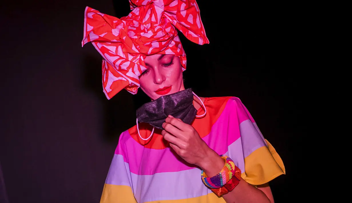 Model memegang masker sebelum peragaan busana perancang Agatha Ruiz de la Prada dalam Mercedes-Benz Fashion Week di Madrid, Spanyol, Kamis (10/9/2020). Acara yang digelar di tengah pandemi COVID-19 berlangsung pada 10-13 September 2020 dengan menerapkan protokol kesehatan. (AP Photo/Bernat Armangue)