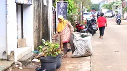 Pengumpul barang bekas mencari barang rusak akibat banjir di Ciledug Indah, Tangerang, Banten, Senin (21/2./2021). Pasca banjir melanda perumahan tersebut menjadi berkah bagi para pengumpul barang rongsok karena banyak barang yang di buang pemilik rumah. (Liputan6.com/Angga Yuniar)