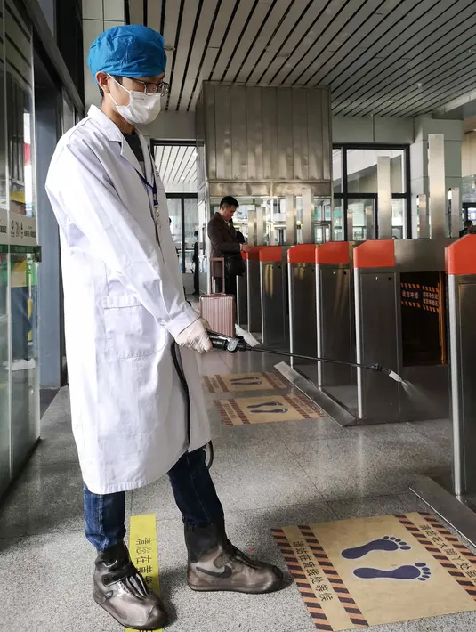 Petugas menyemprotkan cairan disinfektan di Stasiun Kereta Api Yingtan di Nanchang di Provinsi Jiangxi Tengah, China (22/1/2020). Selain menewaskan 17 orang, virus corona juga telah menginfeksi lebih dari 571 orang, termasuk di Taiwan, Jepang, Thailand, Korea Selatan, dan AS. (AFP Photo/STR)