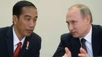 Presiden Rusia, Vladimir Putin (kanan) berbincang dengan Presiden RI, Jokowi saat menghadiri upacara penandatanganan seusai pertemuan di Sochi, Rusia, Rabu (18/5). Keduanya melakukan pertemuan bilateral sebelum KTT ASEAN-Rusia. (Host Photo Agency/AFP)