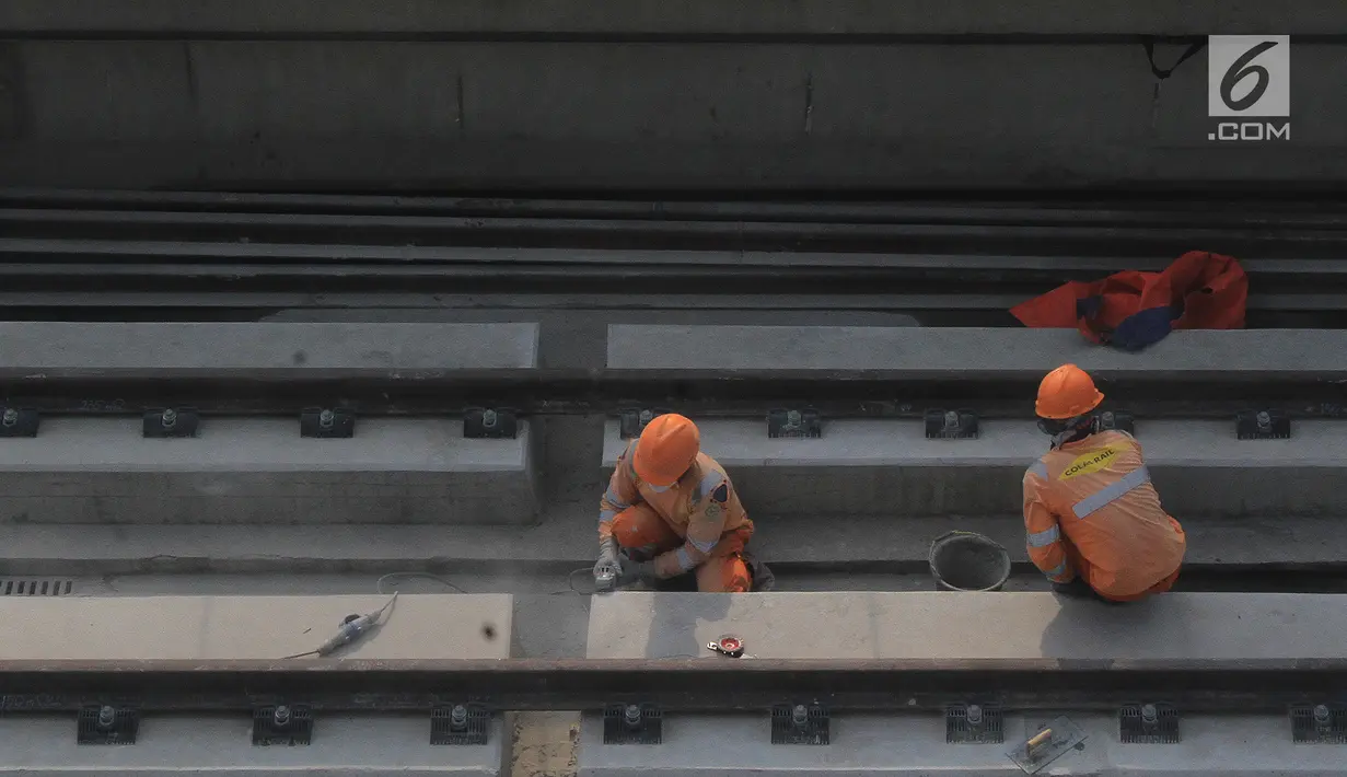 Pekerja menyelesaikan Rel Light Rail Transit (LRT) di Jakarta, Selasa (26/2). Light Rail Transit (LRT) Jabobek trase Cawang–Cibubur bakal diujicoba pada pertengahan tahun ini. (Liputan6.com/Herman Zakharia)