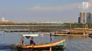 Nelayan melintasi area permukaan air laut yang menyurut di sekitar pesisir Kamal Muara, Jakarta, Kamis (15/3). Fenomena turunnya permukaan air di daerah ini lebih terlihat jelas ketika laut tidak pasang. (Merdeka.com/Iqbal S Nugroho)