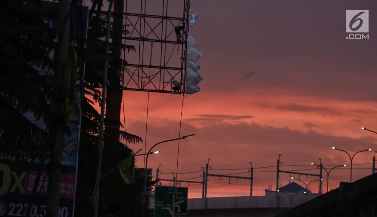 Dua pekerja memotong papan reklame yang telah tidak digunakan di kawasan Jalan TB Simatupang, Jakarta, Senin (11/2). Pemerintah Provinsi DKI Jakarta menganggarkan Rp 11 miliar untuk penertiban reklame ilegal. (Liputan6.com/Faizal Fanani)