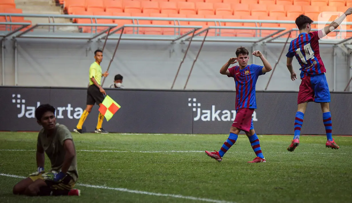 Pemain Barcelona U-18 Jan Molina Vilaseca (kanan) melakukan selebrasi usai mencetak gol ke gawang Bali United U-18 pada pertandingan International Youth Championship (IYC) 2021 di Jakarta International Stadium (JIS), Jakarta, Minggu (17/4/2022). Barcelona U-18 menang 3-0.(Liputan6.com/Faizal Fanani)