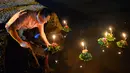 Seorang pria bersiap menghanyutkan lentera air dalam Festival Loy Krathong di Bandar Seri Begawan, Brunei (31/10/2020).  Sekitar 250 orang termasuk sejumlah warga Thailand yang tinggal di Brunei menghanyutkan lentera air untuk perdamaian dan keberuntungan. (Xinhua/Jeffrey Wong)